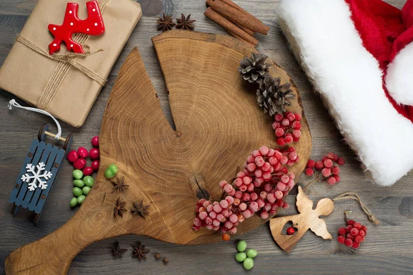 新年とクリスマスの背景 まな板 赤い果実 スパイスや調味料 コーン 灰色の背景にお菓子 — ストック写真