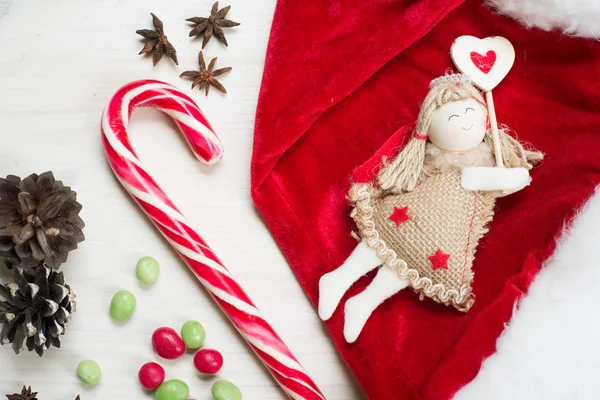 新年とクリスマスのコンセプトです クリスマス ツリー グッズ天使の上に白い木製の背景のサンタ帽子 — ストック写真