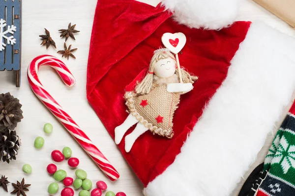 新年とクリスマスのコンセプトです クリスマス ツリー グッズ天使の上に白い木製の背景のサンタ帽子 — ストック写真
