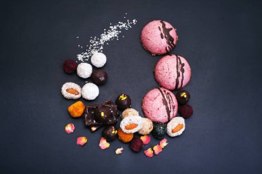Çiğ vegan yararlı tatlılar ve pastalar karanlık bir arka plan üzerinde. Diyet tatlılar ev yapımı.