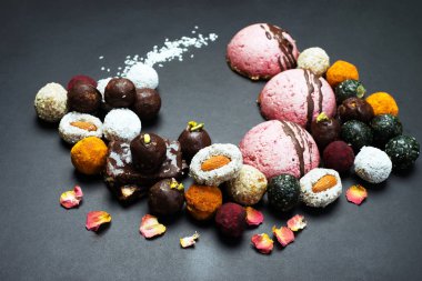Çiğ vegan yararlı tatlılar ve pastalar karanlık bir arka plan üzerinde. Diyet tatlılar ev yapımı.