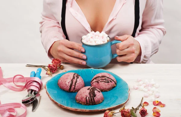 Vegan cashew cakes on a blue plate. In the background is a fragment of the female body. Delicious and healthy breakfast without sugar