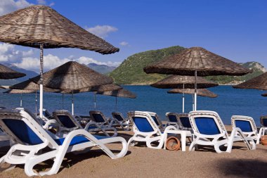 Marmaris, Türkiye'de plaj. Hasır ve mavi yatak, parlak mavi gökyüzü ve deniz şemsiyeleri. Seyahat ve tatil konsepti