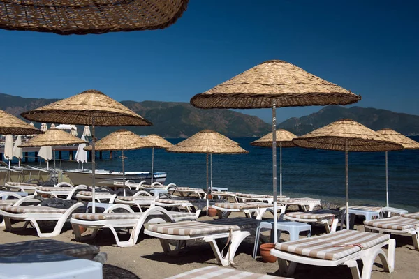 Beach. Şemsiyeler ve şezlonglar, parlak mavi gökyüzü ve deniz. Seyahat ve tatil konsepti