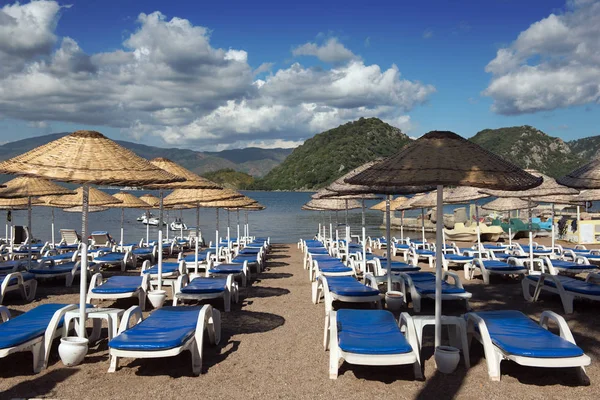 Beach. Şemsiyeler ve şezlonglar, parlak mavi gökyüzü ve deniz. Seyahat ve tatil konsepti