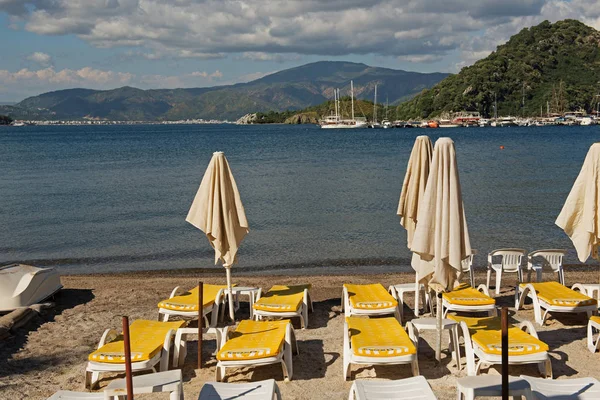 Marmaris, Türkiye'de plaj. Şemsiyeler ve şezlonglar, parlak mavi gökyüzü ve deniz. Seyahat ve tatil konsepti