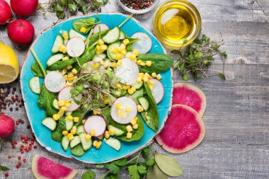 Sağlıklı vitaminli organik vejetaryen yiyecekler. Ispanak, turp, mısır, mikro yeşil zeytinyağı ve limon suyundan yapılmış salata.