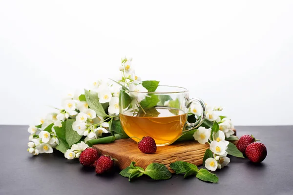 El té verde con el jazmín en la taza a la tabla oscura. Fondo blanco. — Foto de Stock