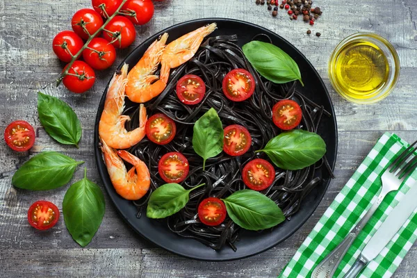 Zwarte pasta (met zwarte inktvis inkt), cherry tomaten, garnalen — Stockfoto