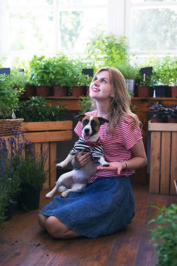 Verandada bir köpekle oynayan güzel genç kadın, nerede t