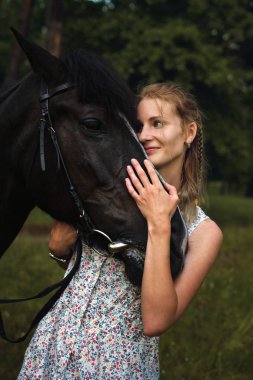 Ön planda bir at ile genç güzel kadın
