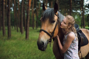 Ön planda bir at ile genç güzel kadın