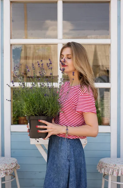 Eine junge schöne Frau (blond im rot-weißen T-Shirt) ist holdi — Stockfoto