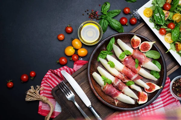 Koyu bir arka plan üzerinde jamon ile kavun meze. Kiraz tom yakınında