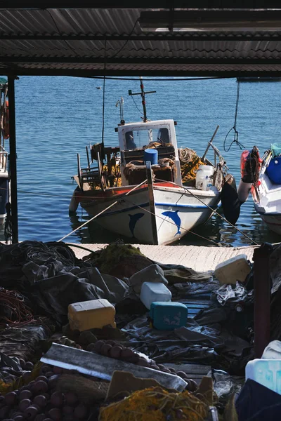 Barco de pesca perto da doca no mar. Redes e acessórios para peixes — Fotografia de Stock