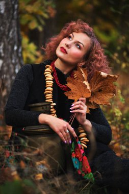 Modern Slav tarzı giyinmiş güzel bir genç kız oturuyor.