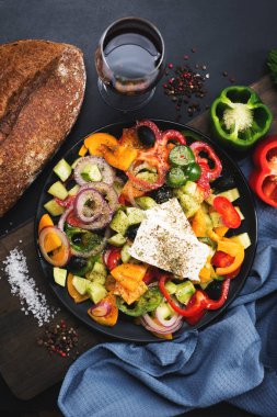 Siyah tabakta klasik Yunan salatası. Ekmeğin yanında, bir bardak W