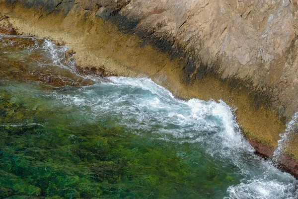 Meereswellen plätschern an den Felsen grüne üppige Natur umgibt t — Stockfoto