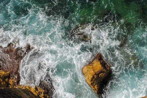 Meereswellen plätschern an den Felsen grüne üppige Natur umgibt t — Stockfoto