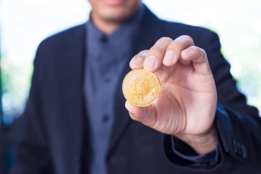 Bir Bitcoin, cryptocurrency jeton seçici odak elinde tutan işadamı
