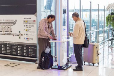 Bangkok, Tayland - 21 Temmuz 2018 - erkek turistler kendi telefon Suvarnaphumi Uluslararası Havaalanı, Bangkok, Tayland tarihinde 21 Temmuz 2018 yılında ücretsiz şarj istasyonu şarj
