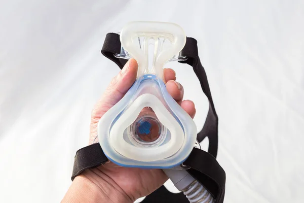 Manlig Hand Hålla Cpap Mask Över Vit Säng — Stockfoto