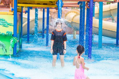 Phuket, Tayland - 8 Temmuz 2017 - küçük kız mutlu bir kadın genç başında Splash orman su parkında Phuket, Tayland için 8 Temmuz 2017 üzerinde dökülen su almak ayakta saatler