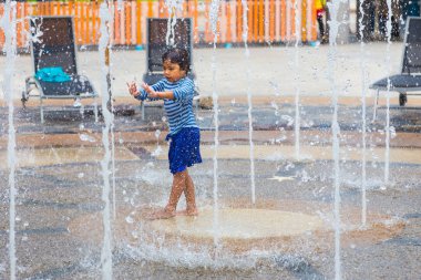 Phuket, Tayland - 8 Temmuz 2017 - genç kız su Su Çeşmesi alanda Splash orman su parkında Phuket, Tayland için 8 Temmuz 2017 üzerinde çekim ile oynamaktan hoşlanıyor  