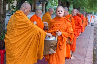 Luang Prabang, Laos üzerinde 29 Haziran 2018 sokak boyunca sunan gıda almak için sabahın erken saatlerinde Luang Prabang, Laos - 29 Haziran 2018 - Laos rahipler yürür