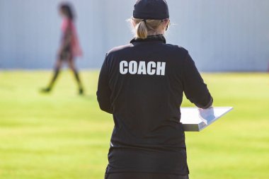 Koç gömlekli bir açık spor alanı, spor direktörü arkadan görünüm