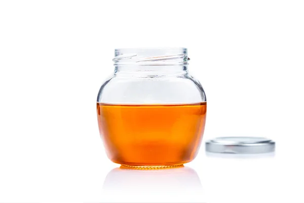 Tarro de vidrio de miel sobre fondo blanco con espacio de copia — Foto de Stock