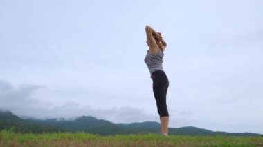 Güzel Asyalı atlet kadın arka planda göl ve dağların manzarası ile bir göl parkında onu sabah egzersiz yapıyor, sağlıklı yaşam tarzı