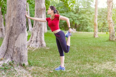 Daha önce bacak Germe genç atlet kadının yan görünümü ve bir
