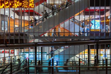 Bir iş binasıyukarı ve aşağı gitmek için yürüyen merdiven kullanan insanlar