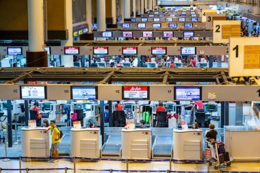 Yolcular Bangkok, Tayland'daki Don Muang Uluslararası Havaalanı check-in kontuarlarında uçuşlarını kontrol etmek için sırada bekliyorlar 