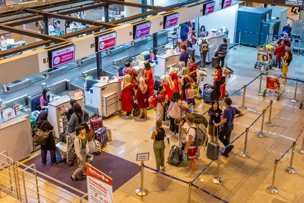 Passagiere stehen Schlange, um ihren Flug am internationalen Check-in-Schalter des Don Muang Flughafens in Bangkok, Thailand, einzuchecken — Stockfoto