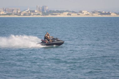 Acre, İsrail - 11.05.2018: Spor aktif dinlenme Akdeniz üzerinde. Jet ski, su scooter yarış iki delikanlı. Etkin yaz tatili. Arka plan şehir Acre Panoraması nedir