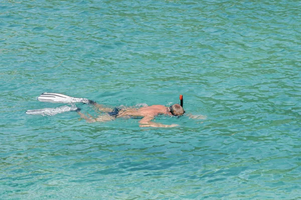 Als erwachsener Mann schnorchelt der Rentner im türkisfarbenen Wasser der Adria. Gesunder Holunder genießt den Sommertag im Freien. Aktivität Freizeit. Aktives Rentenkonzept — Stockfoto