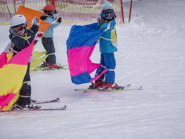 Zams, Österrike-22 Februar 2015: aktiva barn med skyddshjälm, skyddsglasögon. Lektion i Ski Alpine School. Fjärilar på snön. Vintersemester i skidorten — Stockfoto