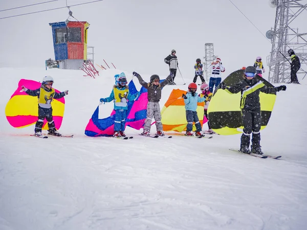 Замс, Австрия - 22 февраля 2015: Активные дети в защитных шлемах, очках. Урок в лыжной альпийской школе. Бабочки на снегу. Зимние каникулы — стоковое фото