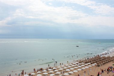 Yaz aylarında plaj Resort Golden Sands Bulgaristan görünümü. Tatilciler, tekne, şezlongve şemsiyeler ile kumlu plaj ve deniz ufku panoramik üst görünümü. Parlak deniz manzarası