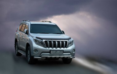 Toyota Land Cruiser Prado bulanık bulutların arka planında.