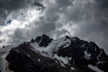 Dağların tepesinde bulutlarla kaplı manzara.