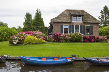GIETHOORN, NETHERLANDS - evlerin ve bahçelerin tipik Hollanda ilçesi