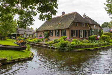 GIETHOORN, NETHERLANDS - evlerin ve bahçelerin tipik Hollanda ilçesi
