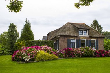 GIETHOORN, NETHERLANDS - evlerin ve bahçelerin tipik Hollanda ilçesi