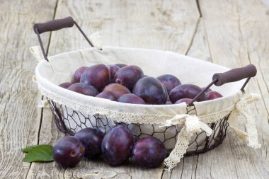 ahşap arka plan üzerinde bir sepet içinde taze erik