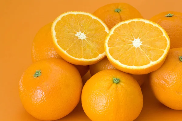 Verse Sinaasappelen Een Oranje Achtergrond — Stockfoto