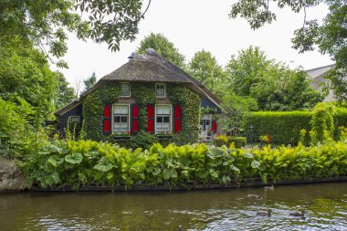 GIETHOORN, NETHERLANDS - evlerin ve bahçelerin tipik Hollanda ilçesi