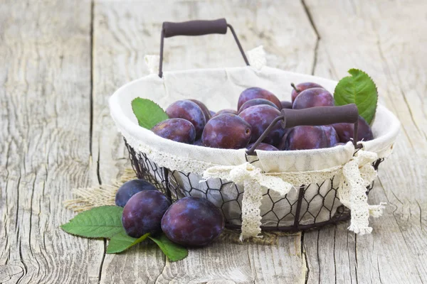 eski ahşap zemin üzerinde bir sepet içinde taze erik